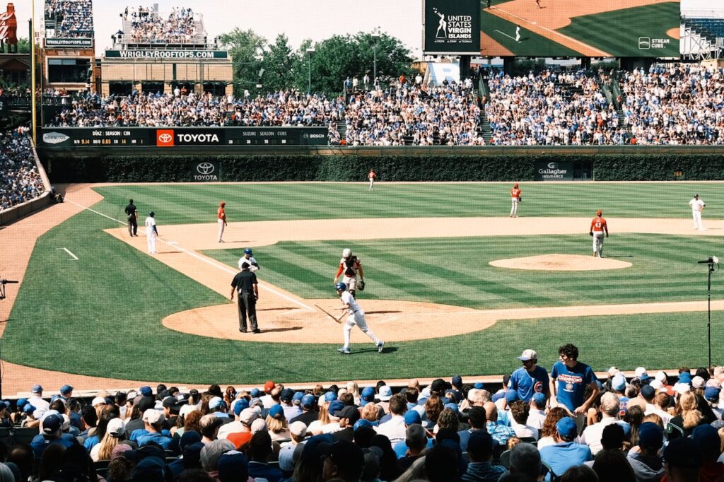 Vibrant scene of a baseball game at Wrigley Field with packed grandstands and players in action.